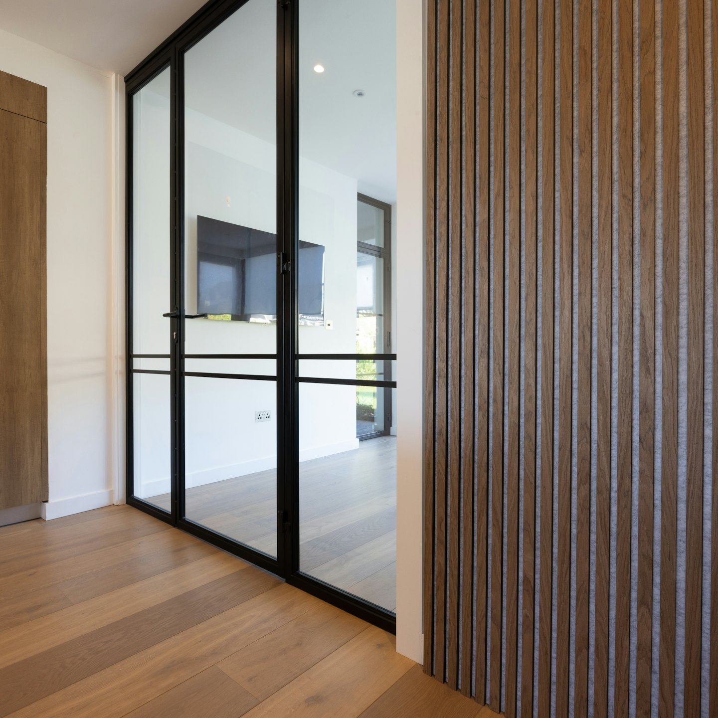 Modern wooden slat wall and glass dividers inside a room.