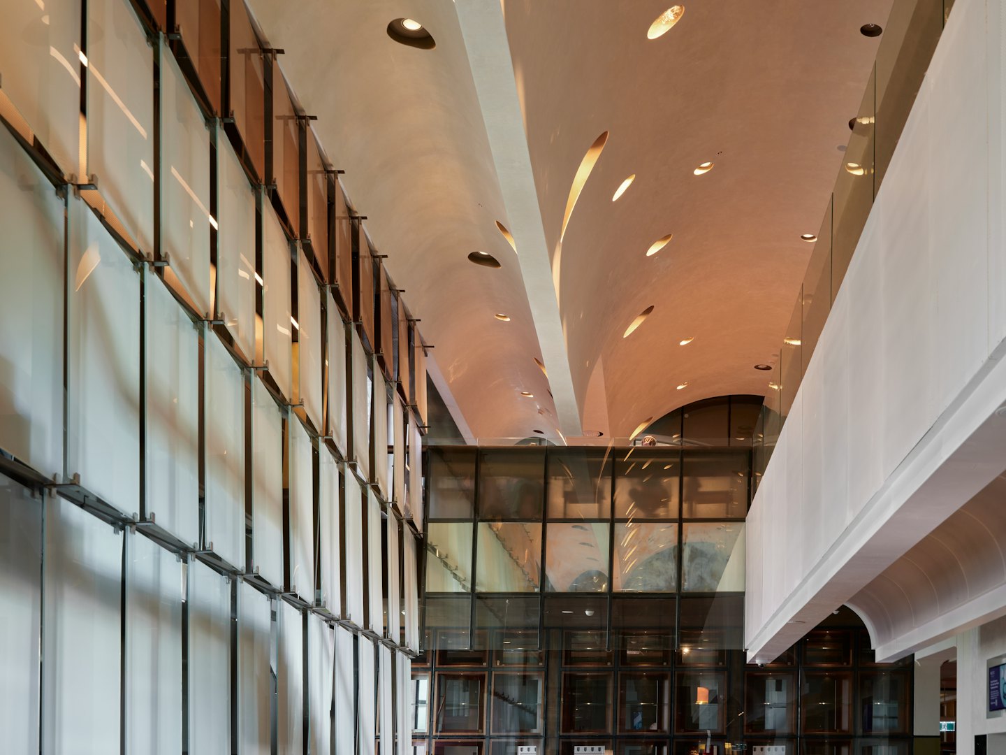 Translucent wall panels leading to a curved beige ceiling with recessed lights.